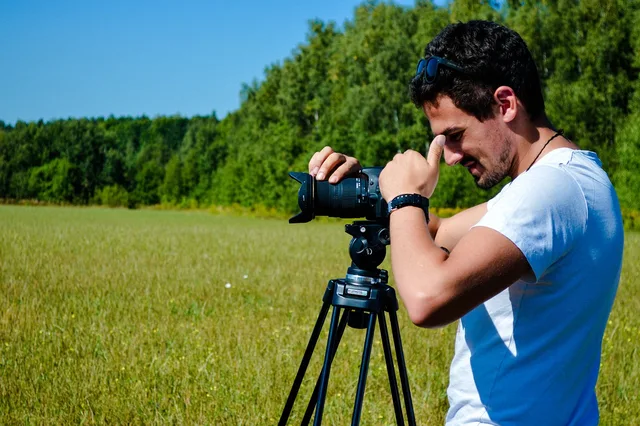 man, camera, photographer, videographer, equipment, tripod, nature, field, grass, photoshoot, cinema. A video marketing agencies planning template without the stalled brief