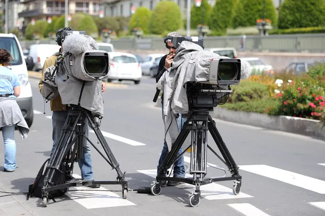 Two cameramen and their professional video camera on a tripod, protected with a rain cover, on Boulevard Eugène Cornuché in front of the Centre international de Deauville to cover the 37th G8 summit in Deauville, France. The crew belongs to video production company AMP VISUAL TV and the cameras are. Video marketing agency due diligence: five checks